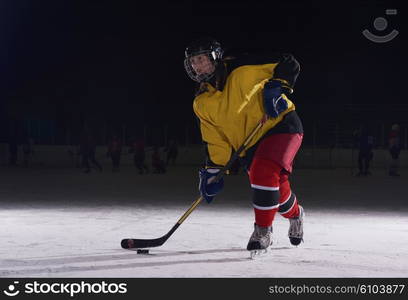 teen girl children ice hockey player in action kicking puck with stick