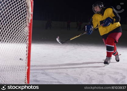 teen girl children ice hockey player in action kicking puck with stick