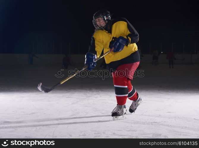 teen girl children ice hockey player in action kicking puck with stick