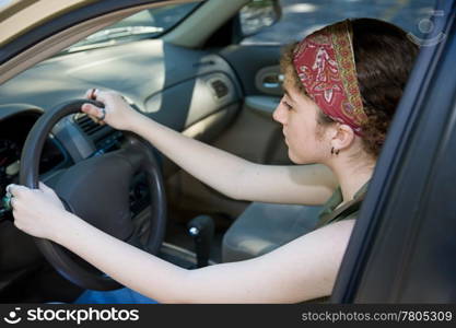 Teen girl concentrates on learning to drive. Focus on the girls face.