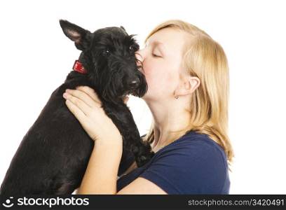 Teen girl giving kisses to her adorable Scotty dog. Isolated on white.
