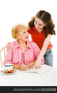 Teen girl helping senior woman fill out absentee ballot. Isolated on white.