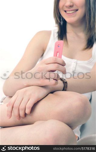 Teen girl holding a pregnancy test tool smiling