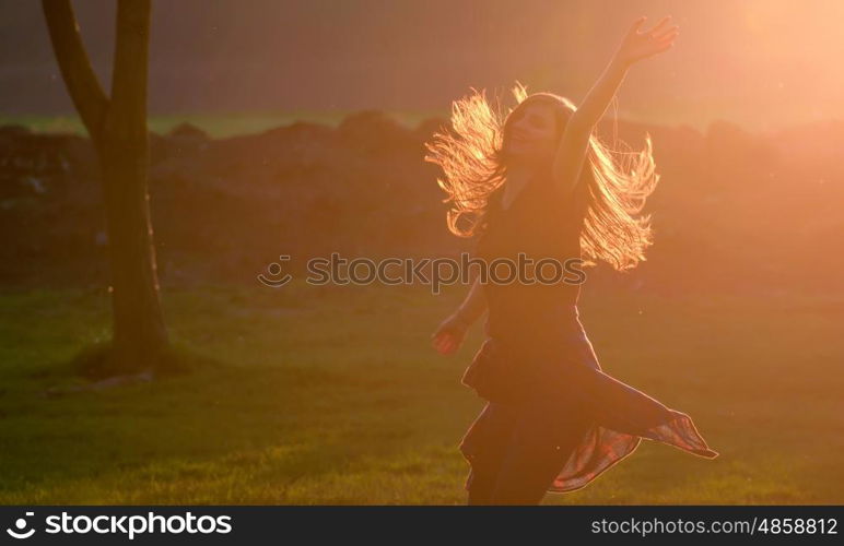 Teen girl jump against beautiful sunset in forest