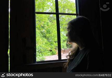 Teen girl look from window in nature. Teen girl look from window