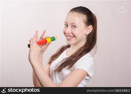Teen girl playing a pipe and smiling faces in the frame