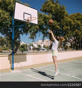 teen girl playing basketball pitch