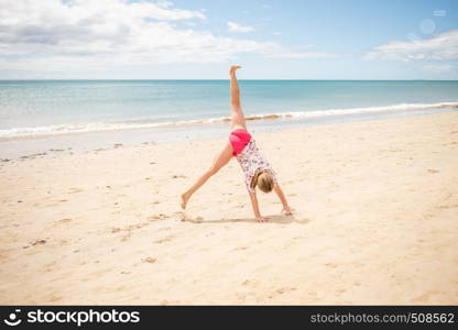 teen girl playing on a beach by sea on holiday