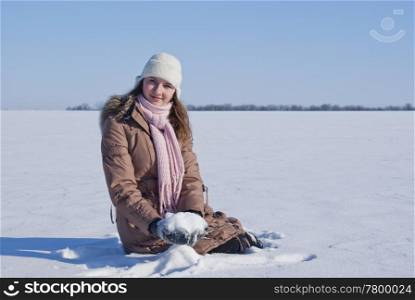 Teen girl sitting in snow