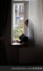 teen girl sitting on a windowsill with a book in the children's room