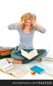 Teen girl sitting on floor among schoolbooks and studying hard isolated on white &#xA;