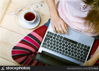 Teen girl sitting with a laptop