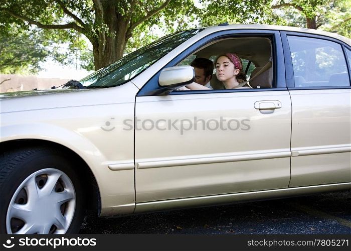 Teen girl taking a car for a test drive. Could also be driving test for license.