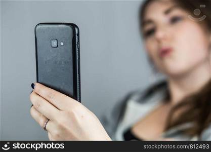 Teen girl taking selfie with duckface with her mobile phone modern hype. Teen girl taking selfie with duckface with her mobile phone