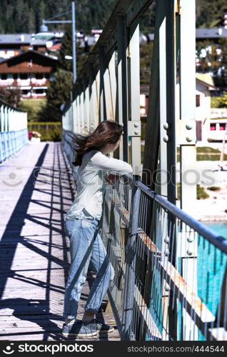 teen girl walking on a bridge, Auronzo di Cadore at the italy