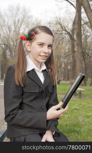 Teen girl with e-book reader in a park