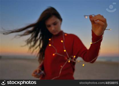 Teen girl with lights on beach