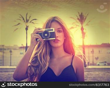 Teen girl with retro photo camera at sunset as a photographer filtered image