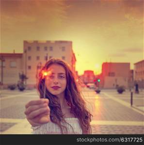 Teen girl with sparklers at sunset sky in the city filtered image