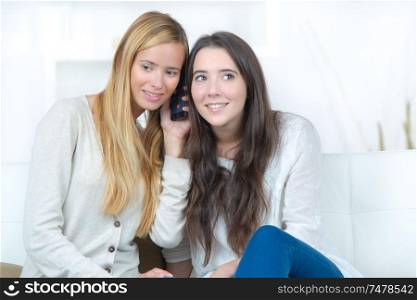 teen girlfriends sharing phone conversation