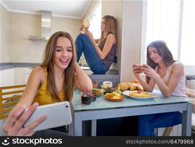 teen girls best friends lunch eating at kitchen. teen girls best friends having lunch eating at kitchen with smartphone