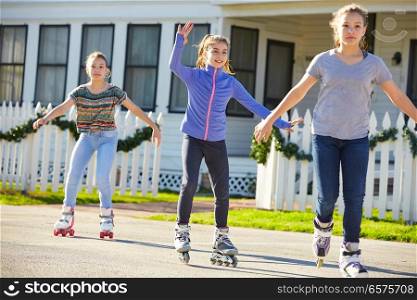 Teen girls group rolling skate in the street outdoor