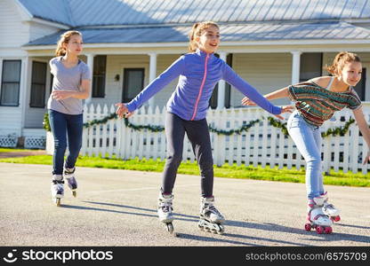 Teen girls group rolling skate in the street outdoor