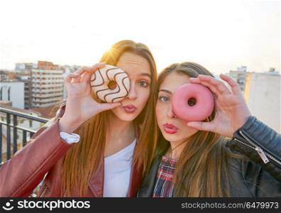 Teen girls portrait with donuts in eye having fun. Teen girls portrait with donuts in eye having fun outdoor