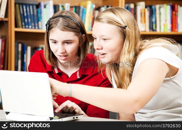 Teen girls using a computer in the library.