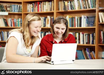 Teen girls using a netbook to do research in the library. Room for Text