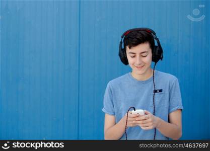 Teen listening to music with headphones on blue background