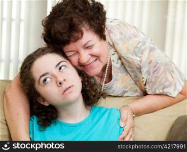 Teen puts up with a hug from an annoying aunt or parent.