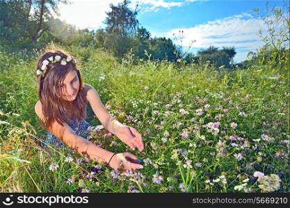 teen sitting outdoors in a flowers field