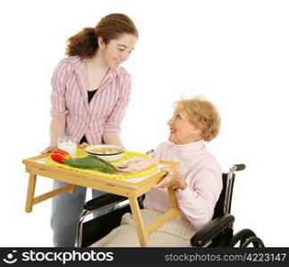 Teen volunteer serving soup to a disabled senior woman. Isolated on white.