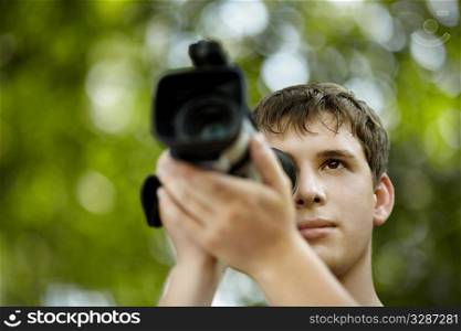 teen with camcorder capturing, selective focus on eye, natural light
