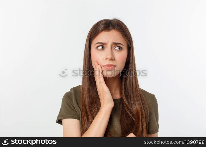 Teen woman pressing her bruised cheek with a painful expression as if she is having a terrible tooth ache.. Teen woman pressing her bruised cheek with a painful expression as if she is having a terrible tooth ache