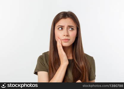 Teen woman pressing her bruised cheek with a painful expression as if she is having a terrible tooth ache.. Teen woman pressing her bruised cheek with a painful expression as if she is having a terrible tooth ache