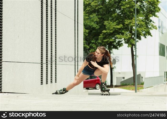 Teen woman wearing roller skates riding fast in city. Female being sporty having fun during summer time.. Young woman fast riding roller skates