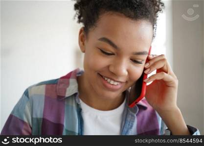 Teenage african american girl talking on cellphone to friend. Young woman speaking and laughing. Teenager is gossiping and listening to the news. Flirting on phone. Conversation and communication.. Teenage african american girl talking on cellphone to friend. Teenager is gossiping and flirting.