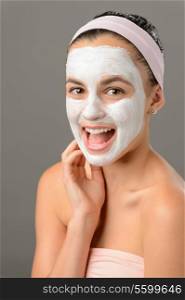 Teenage beauty smiling girl white facial mask on gray background