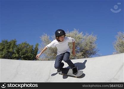 Teenage boy (16-17) skateboarding at skate park