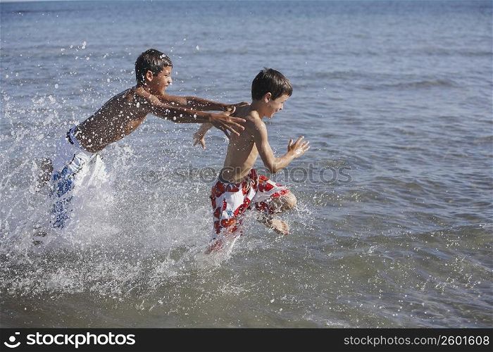 Teenage boy and a boy playing in the sea