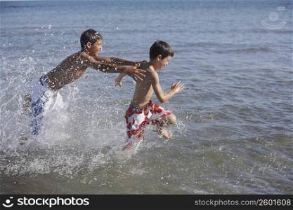 Teenage boy and a boy playing in the sea