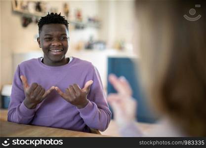 Teenage Boy And Girl Having Conversation Using Sign Language