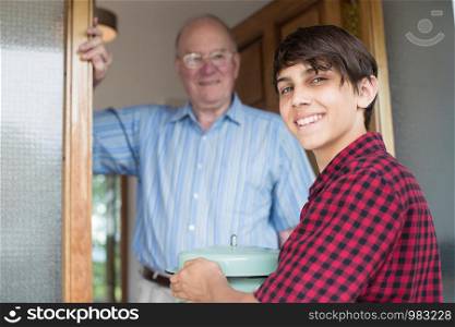 Teenage Boy Bringing Meal For Elderly Male Neighbour