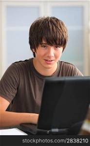 Teenage boy doing his homework on line