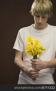 Teenage boy holding flowers