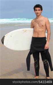 Teenage boy holding surfboard