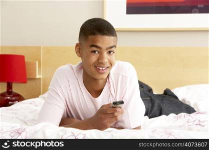Teenage Boy In Bedroom With Mobile Phone