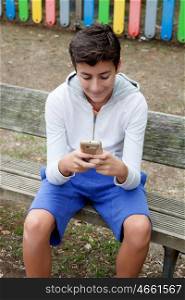 Teenage boy looking the mobile sitting in the street
